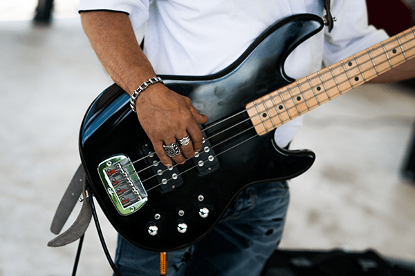 close up on a bass guitar being played at a concert