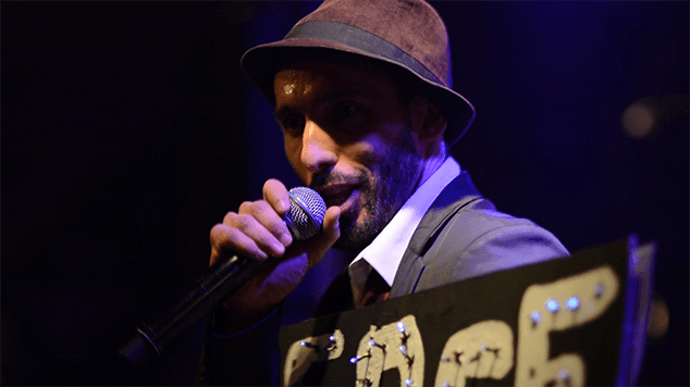 portrait of singer on stage, he's holding a sign