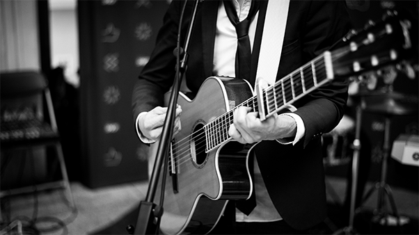 close up of a guitar being played at a concert